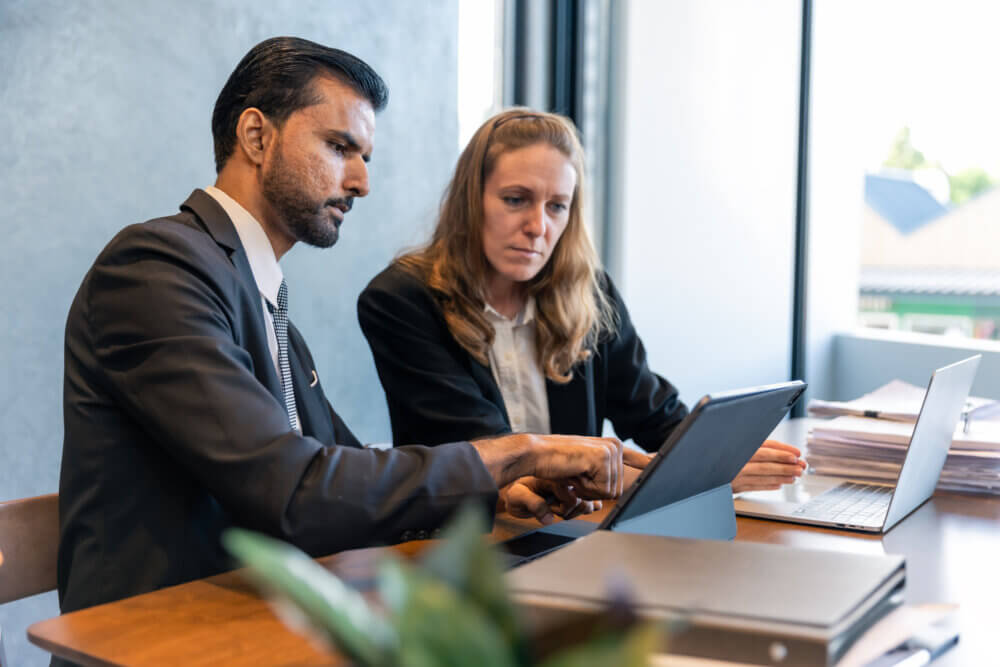 Business Professionals Analyzing Data on Tablet: Teamwork, Strategy, and Project Discussion in a Modern Office