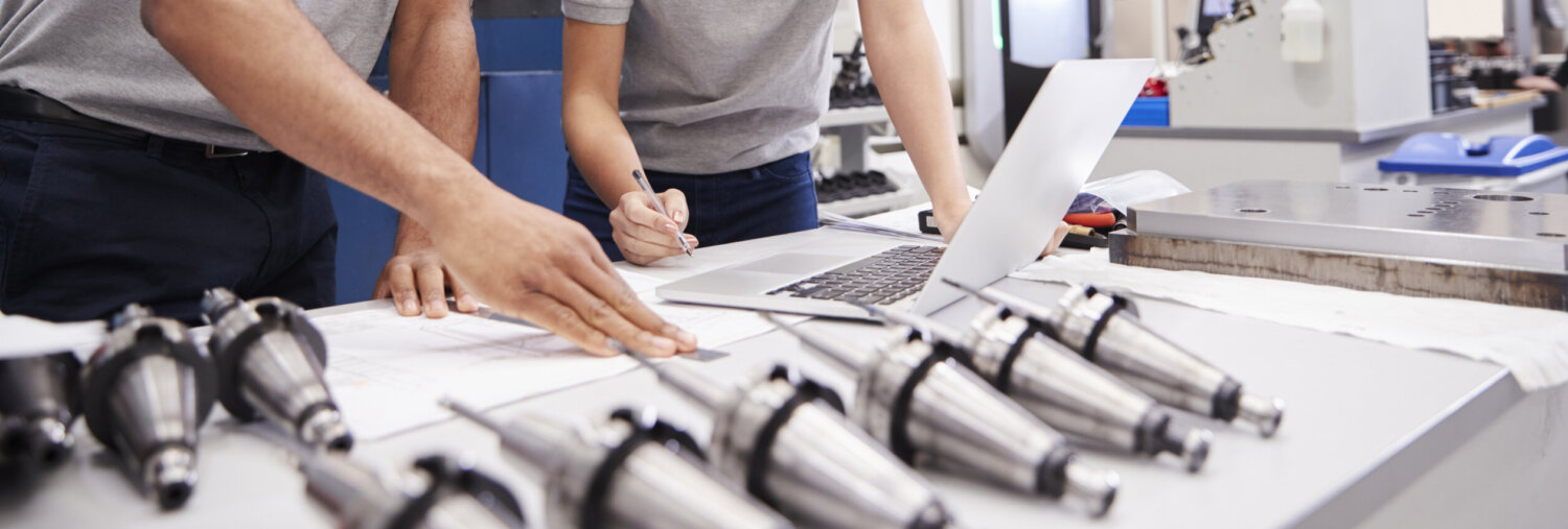 Two Engineers Using CAD Programming Software On Laptop